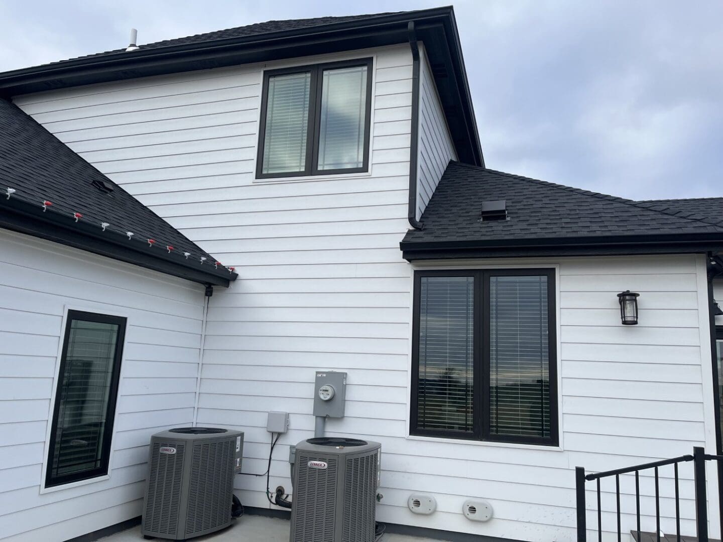 A house with two air conditioners and a window.